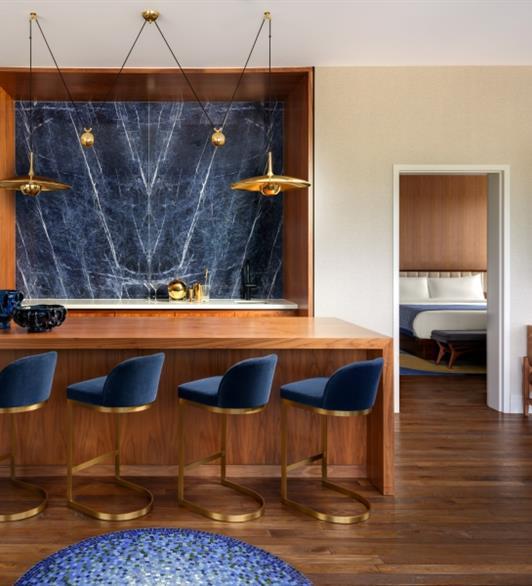 A living space with wood floors, wood countertop and wooden walls and blue chairs
