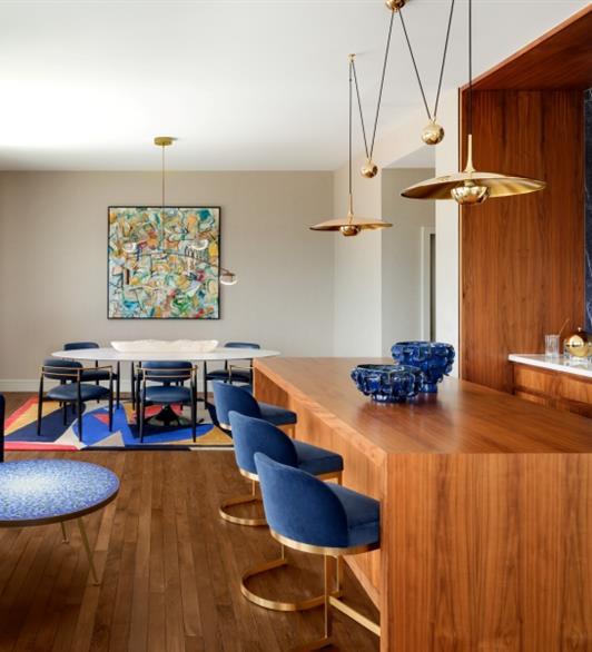 A living space with wood floors, wood countertop and wooden walls and blue chairs