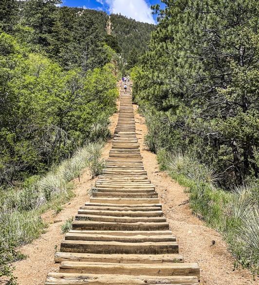 People walking up a lot of steps going up a hill