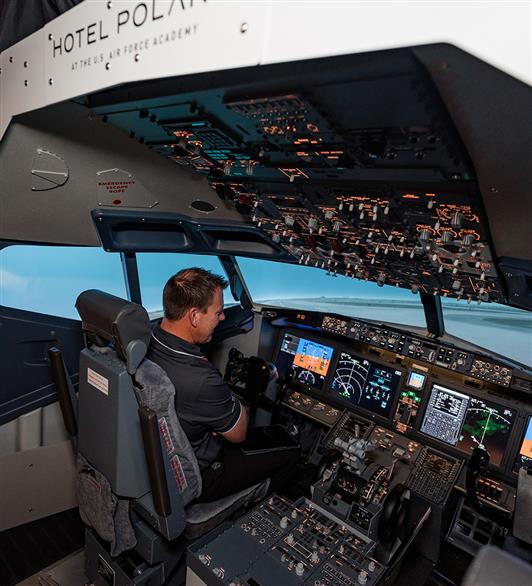 Someone sitting in the cockpit of the flight simulator