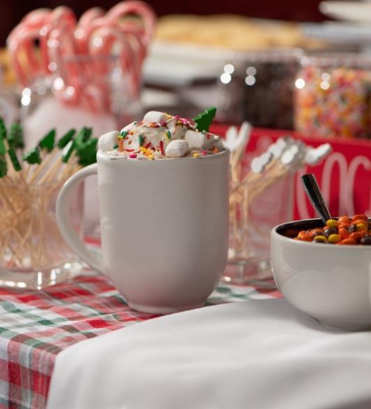 A bunch of Christmas themed candy and drinks on a table