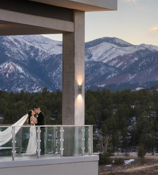 A bride and groom kissing on the balcony