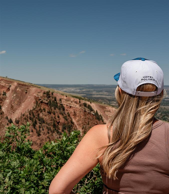 Hotel Polaris branded hat on a person looking out at mountains