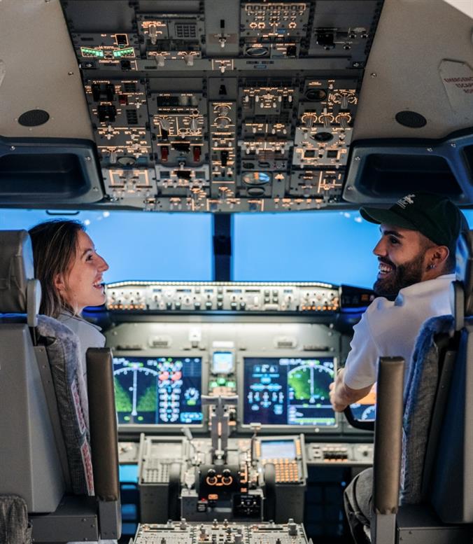 Two people enjoying the flight simulator