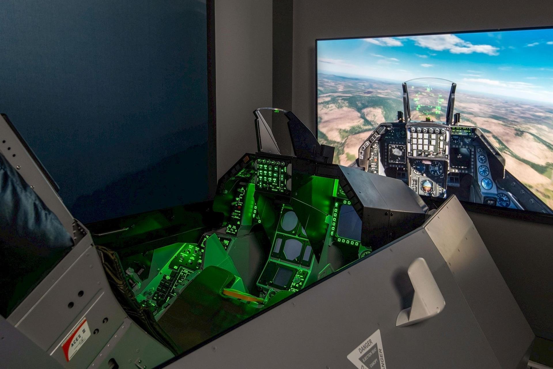 Fighter jet flight simulator at Hotel Polaris featuring a realistic cockpit with illuminated controls and a large display showing an immersive aerial flight experience.