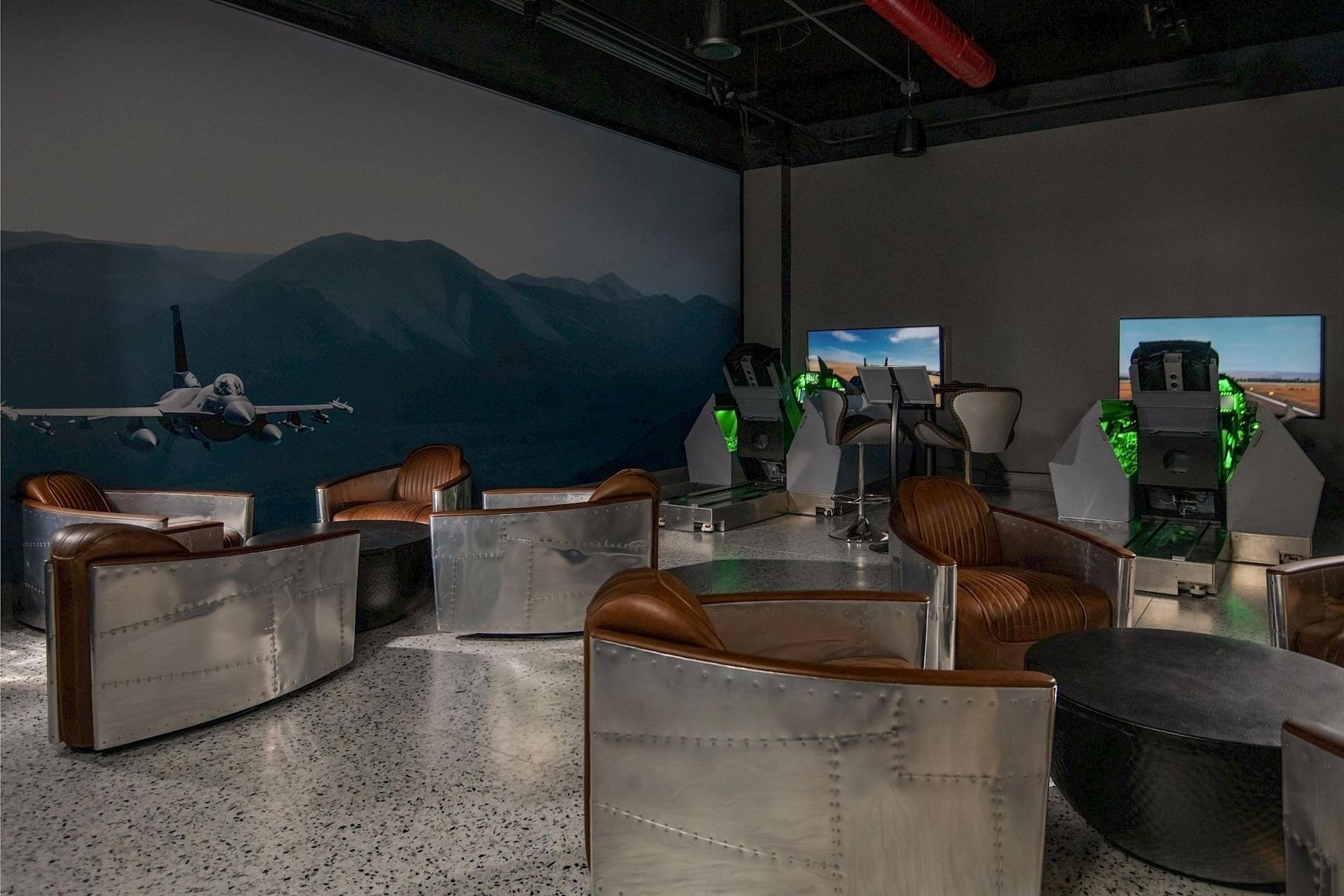 Aviation-themed lounge at Hotel Polaris featuring leather club chairs, aircraft-inspired furnishings, and immersive fighter jet flight simulators for guests to enjoy.
