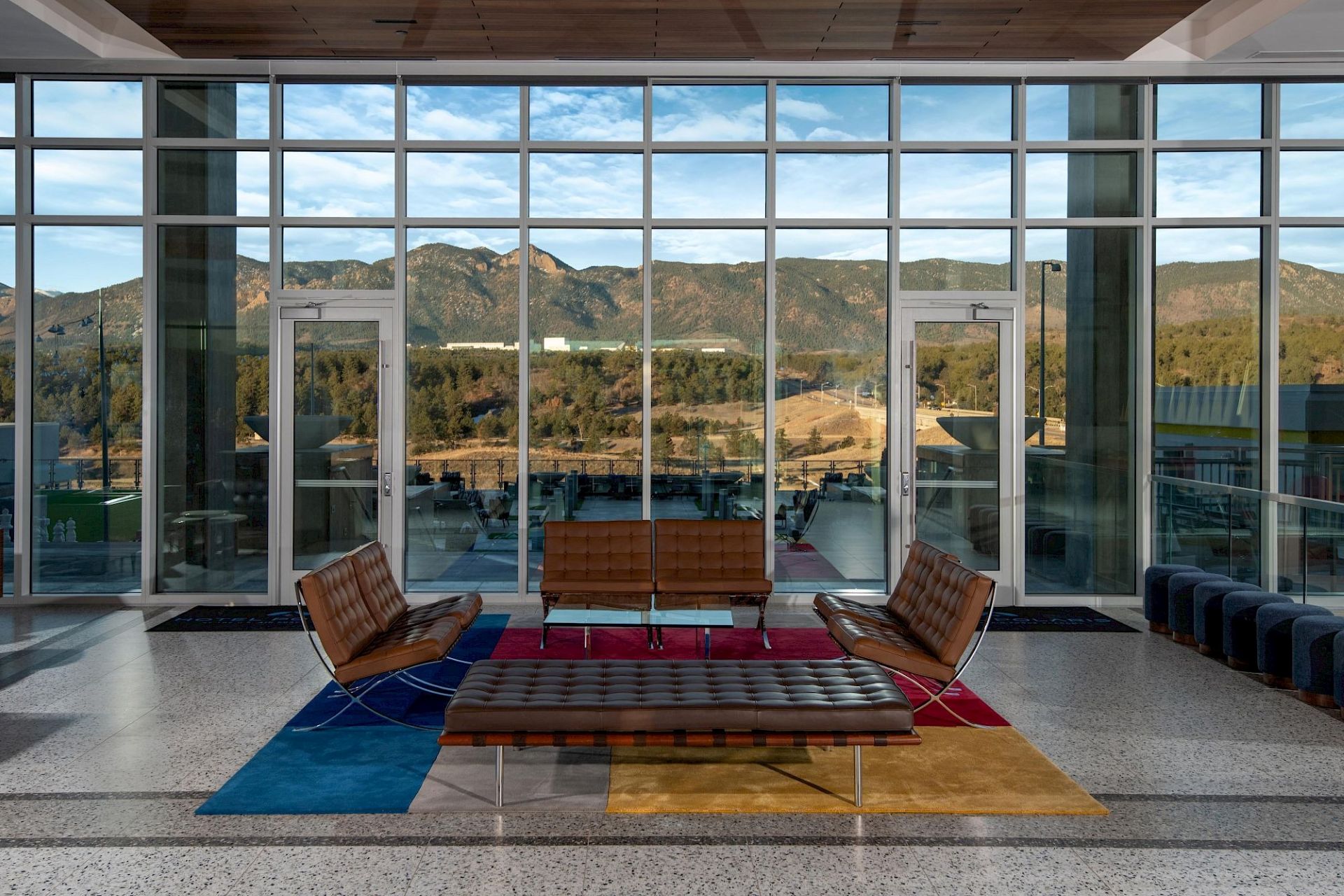 Hotel Polaris lobby seating area overlooking the mountains through expansive floor-to-ceiling windows.