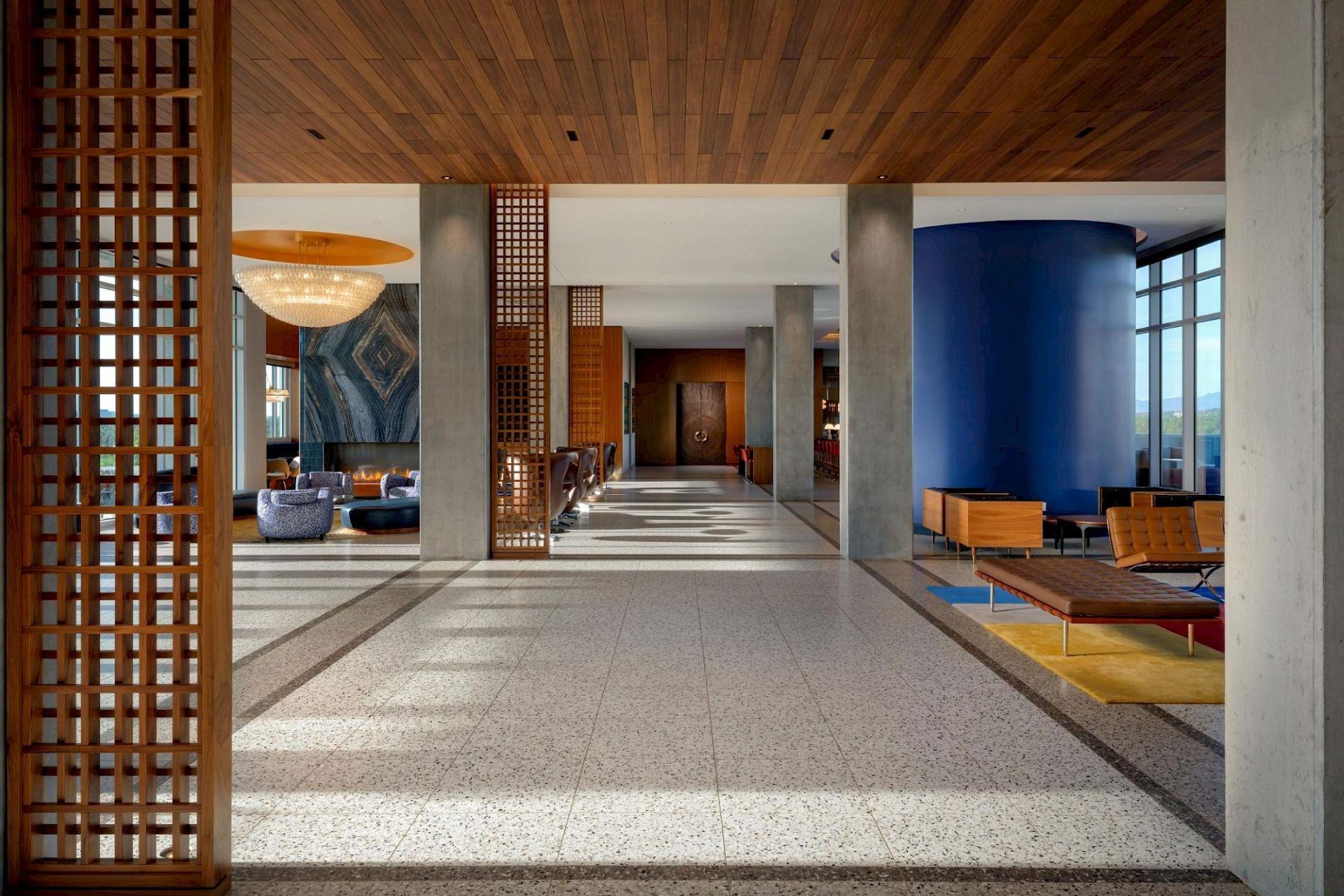 Spacious Hotel Polaris lobby featuring wood lattice details, modern lounge seating, and floor-to-ceiling windows.