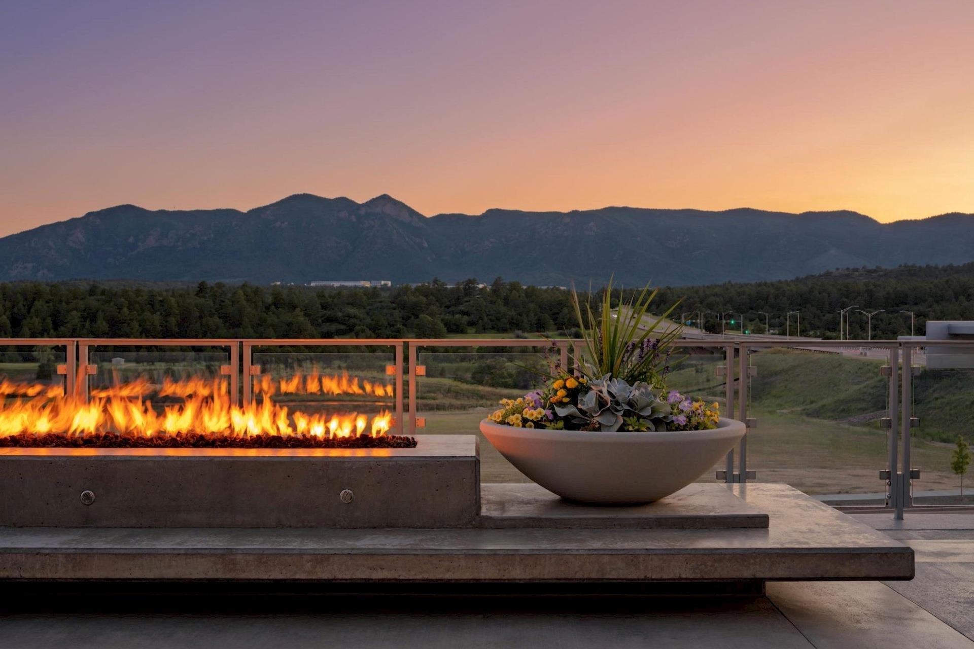 Outdoor fire feature and floral planter at Hotel Polaris overlooking the mountains at sunset.