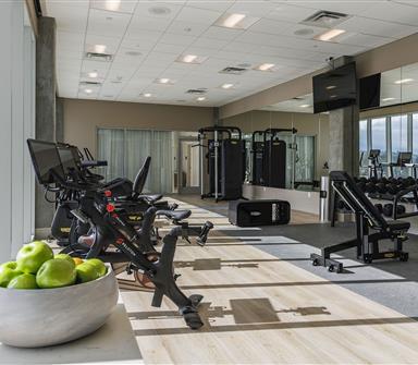 State-of-the-art fitness center at Hotel Polaris featuring Peloton bikes, strength-training equipment, free weights, and floor-to-ceiling windows with scenic Colorado views.