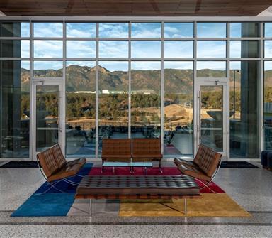 Hotel Polaris lobby seating area overlooking the mountains through expansive floor-to-ceiling windows.