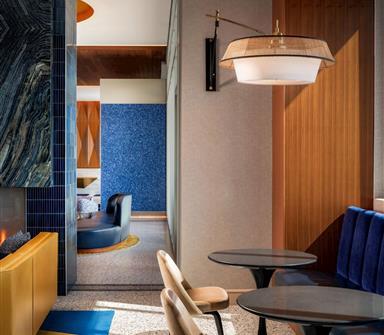 Modern seating area at Hotel Polaris with blue banquette seating, warm wood finishes, and contemporary lighting.