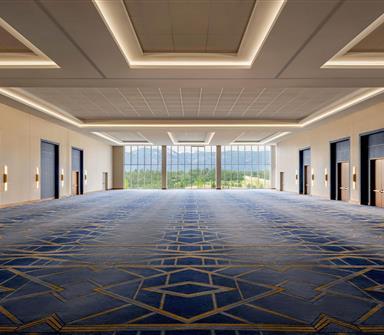Spacious ballroom at Hotel Polaris featuring floor-to-ceiling windows, modern lighting, and flexible event space with panoramic views of the Rocky Mountains.